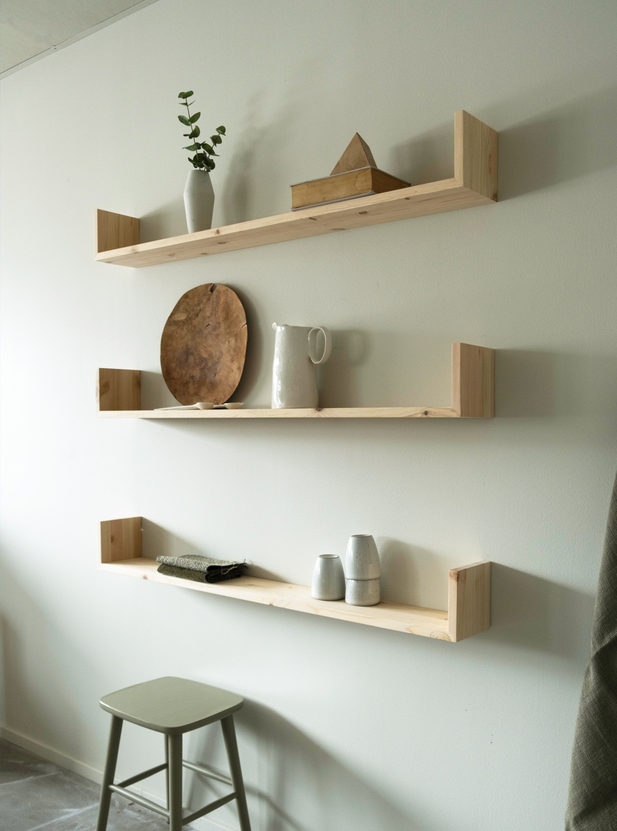 Gren wall shelves in oak decorated with an assortment of items