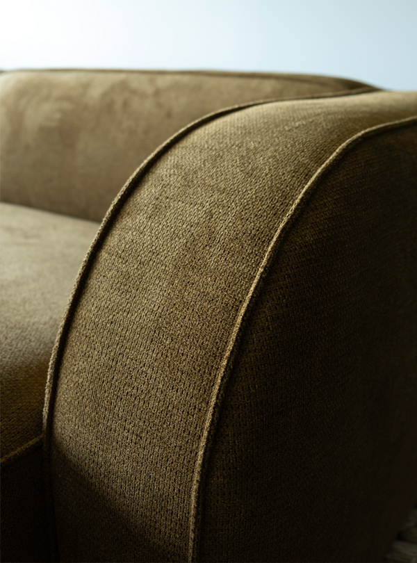 Close-up of the curved armrest and textured brown fabric of the Sva module sofa.